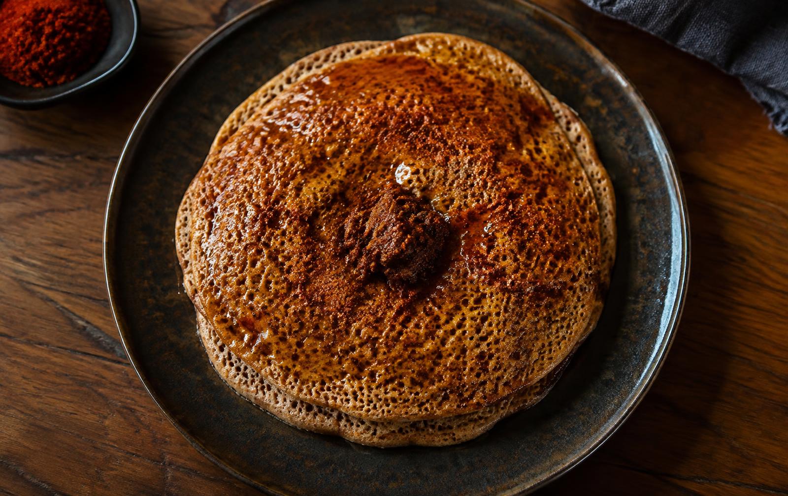 A plate of Anebabero — layered injera with spiced butter and berbere